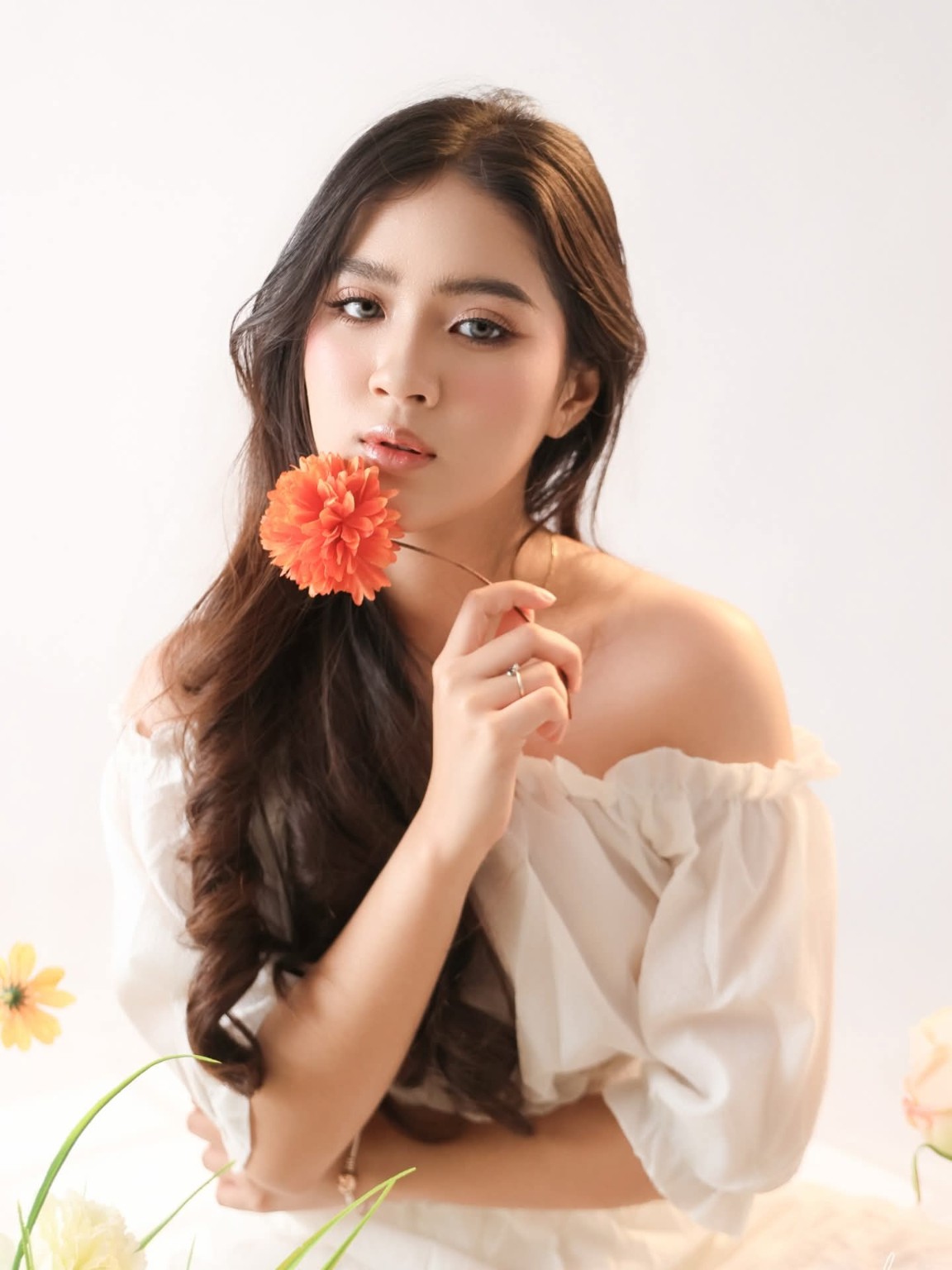 Therese holding an orange flower